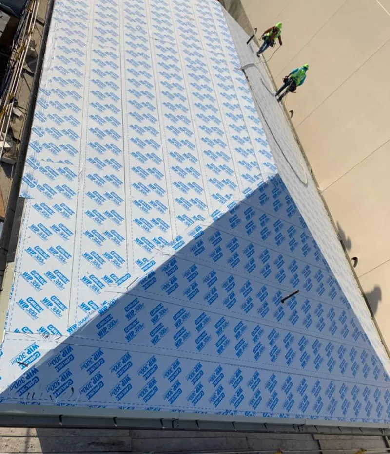 Professional roofers installing underlayment on a metal roof in Farmington